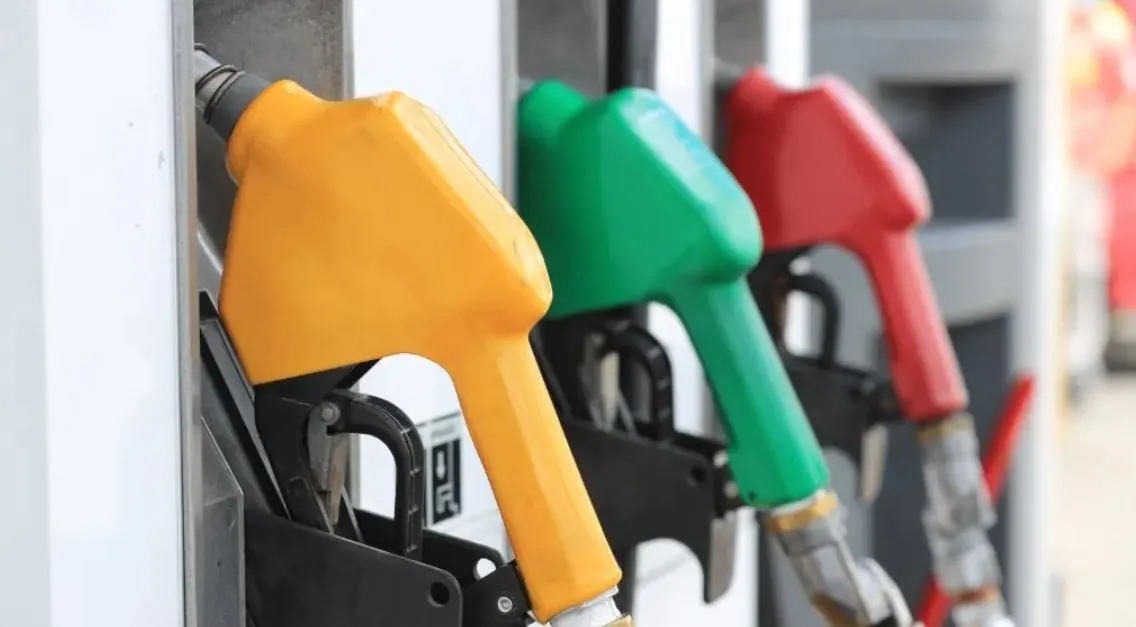 Despachadores de gasolina atienden vehículos en estación de servicio en Guatemala durante aplicación de subsidio a combustibles