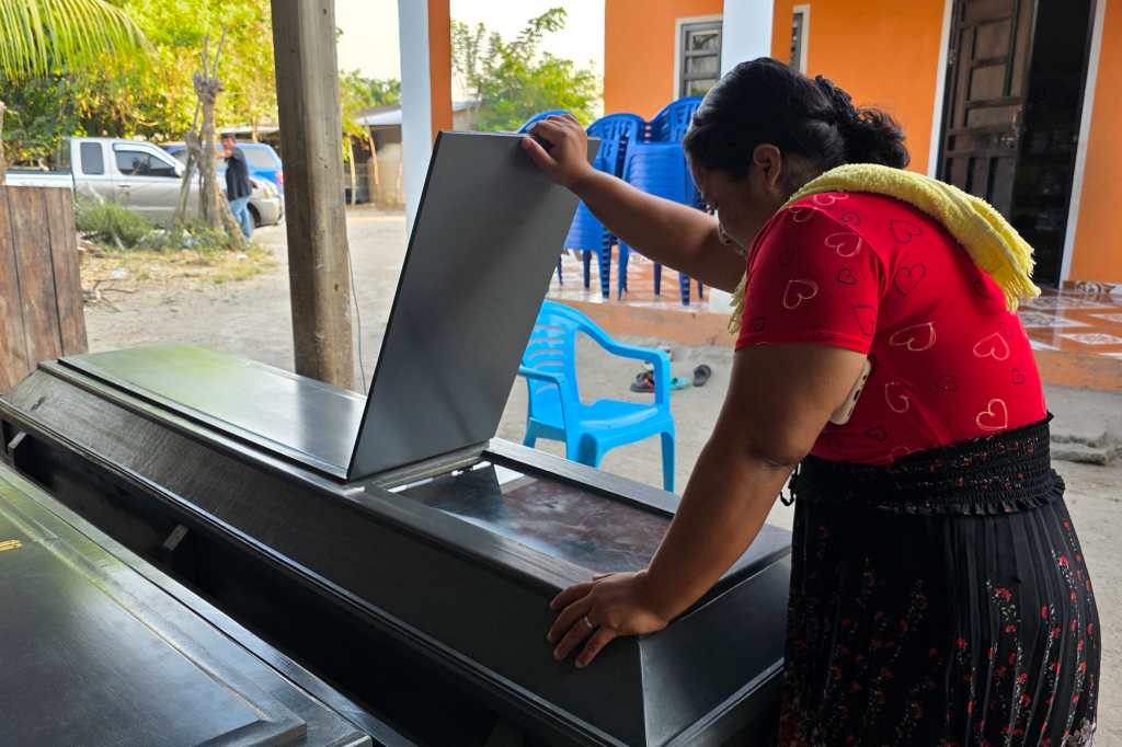 Mujer observa los féretros de Elmer y Wilmer Suchite durante velorio de víctimas de masacre en Rigores, Honduras.