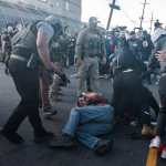 Newark (United States), 29/05/2026.- A protester covers his face after getting knocked down and pepper-sprayed by Immigration and Customs Enforcement (ICE) agents during a protest against the treatment of detainees at the Delaney Hall Detention Facility in Newark, New Jersey, USA, 28 May 2026 (issued 29 May 2026). About 300 detainees at Delaney Hall immigration facility center signed a letter, beginning a hunger strike over detention conditions since 22 May 2026. (Protestas) EFE/EPA/OLGA FEDOROVA