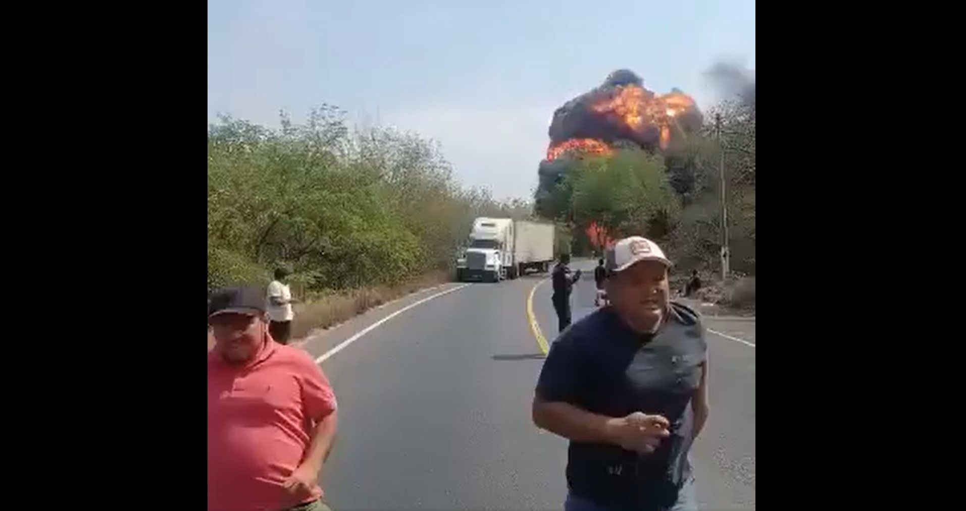 Automovilistas y agentes de la PNC corren para resguardarse durante la explosión de un camión cisterna accidentado en el kilómetro 106 de la ruta al Atlántico, en San Agustín Acasaguastlán, El Progreso. (Foto Prensa Libre: Captura de Pantalla)