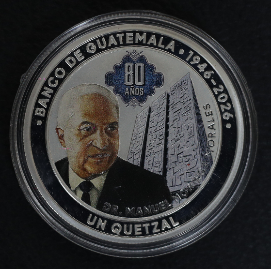 El anverso de la moneda conmemorativa por los 80 años del Banco de Guatemala muestra la leyenda “Banco de Guatemala 1946-2026”, la denominación “Un Quetzal” y un diseño alusivo al aniversario institucional con acabados en color. (Foto, Prensa Libre: Esbin García)