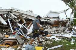 AME442. IZTAPA (GUATEMALA), 10/06/2026.- Una persona camina entre escombros de viviendas destruidas debido al fuerte oleaje y constantes lluvias generadas por la tormenta tropical Cristina este miércoles, en el puerto de Iztapa (Guatemala). Guatemala tiene más de 800 puntos de riesgo a deslaves e inundaciones, entre otros, según cálculos oficiales. EFE/ Alex Cruz