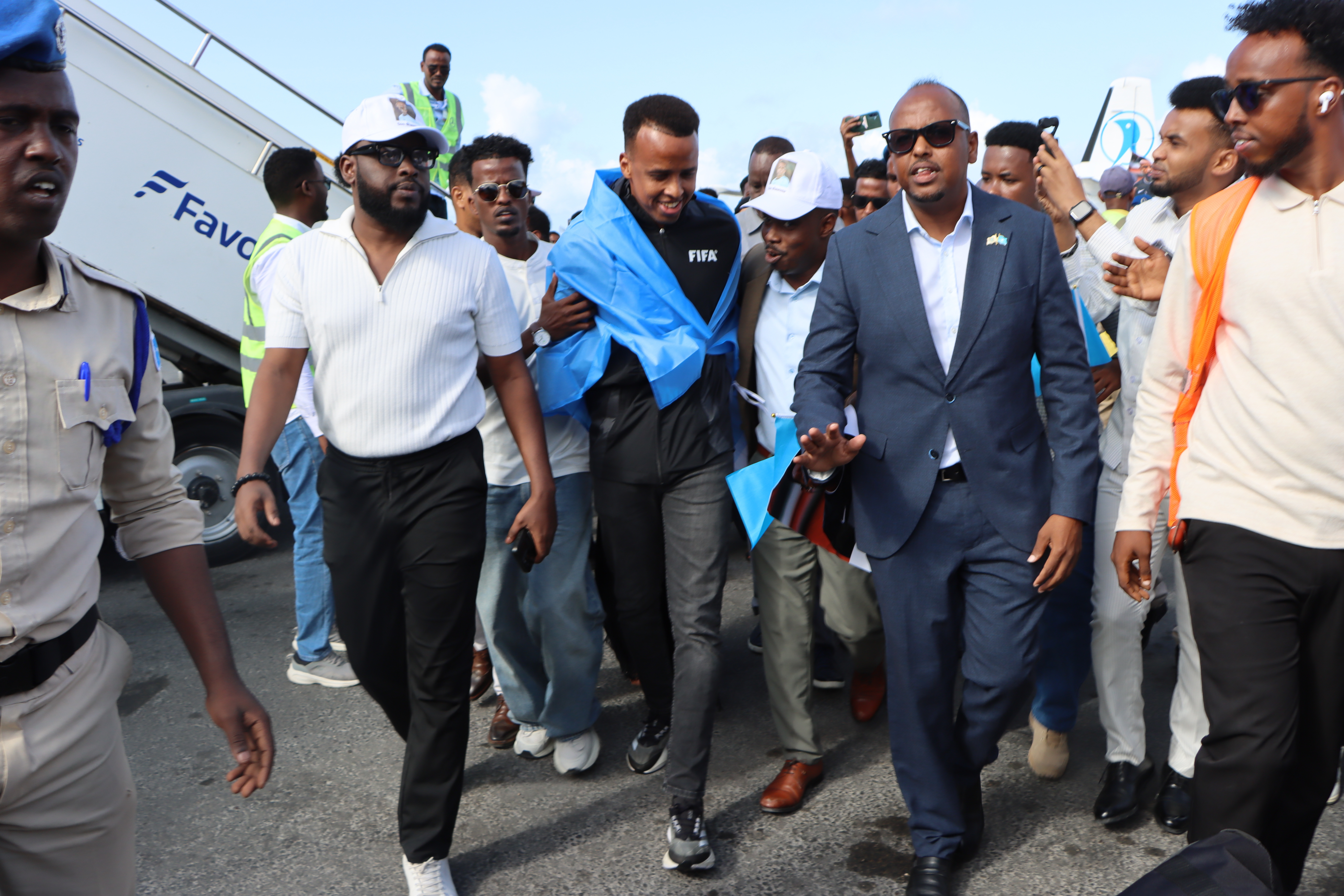 MOGADISHU (Somalia), 10/06/2026.- FIFA referee Omar Abdulkadir Artan (C) is greeted by supporters upon his arrival at the airport in Mogadishu, Somalia, 10 June 2026. Artan was given a hero's welcome after US authorities denied him entry to the 2026 FIFA World Cup. (Mundial de Fútbol, Mogadiscio) EFE/EPA/SAID YUSUF WARSAME