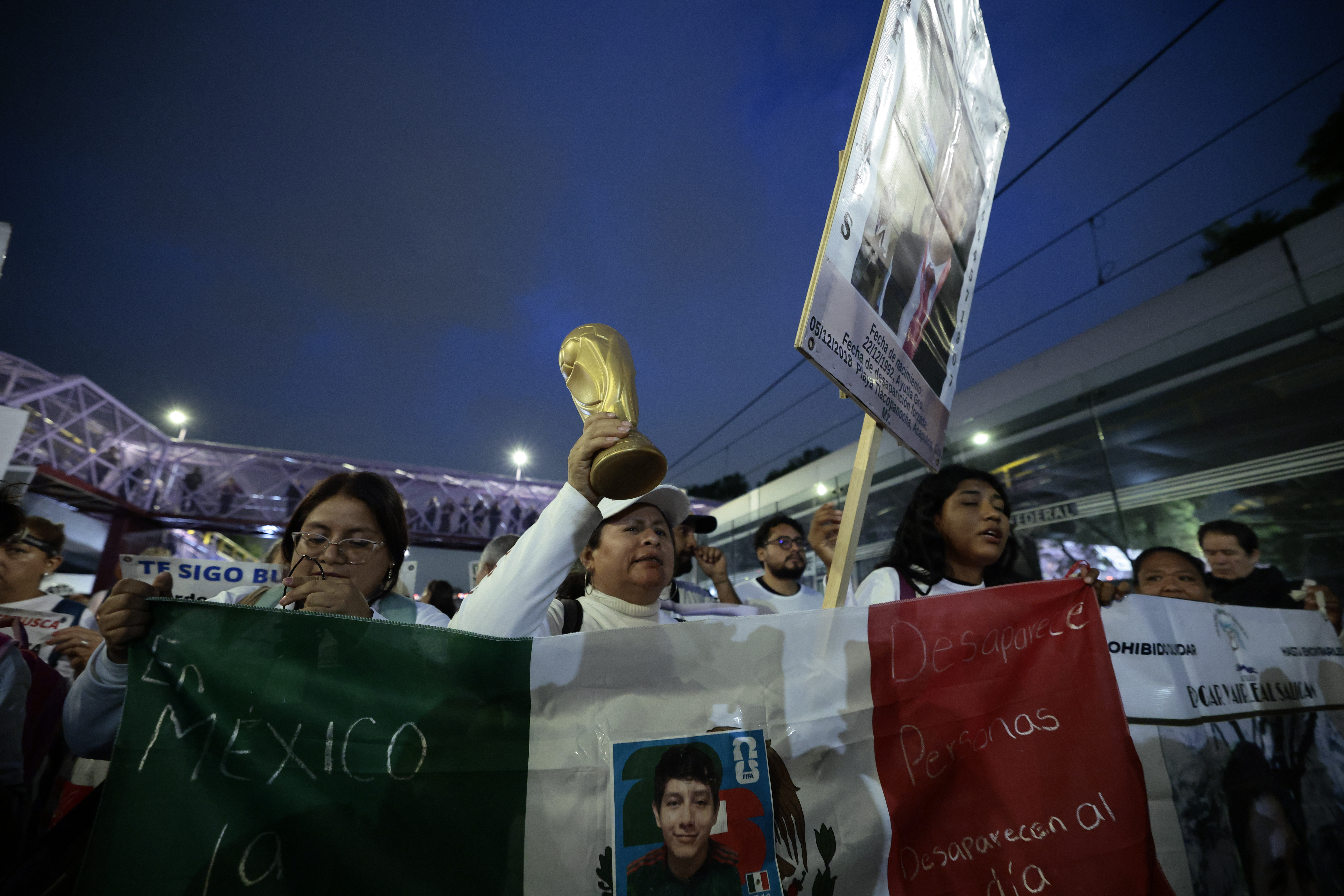 MEX5530. CIUDAD DE MÉXICO (MÉXICO), 11/06/2026.- Personas sostienen carteles durante una protesta este miércoles, previo a la inauguración de la Copa Mundial de Fútbol de la FIFA 2026, en Ciudad de México (México). Miles de manifestantes fueron contenidos por la noche por un fuerte operativo policial cuando intentaban avanzar hacia el Estadio Ciudad de México (Estadio Azteca), donde en unas horas se celebrará la inauguración del Mundial 2026, en busca de visibilizar la situación que enfrenta el país con más de 133.000 personas desaparecidas. EFE/ José Méndez