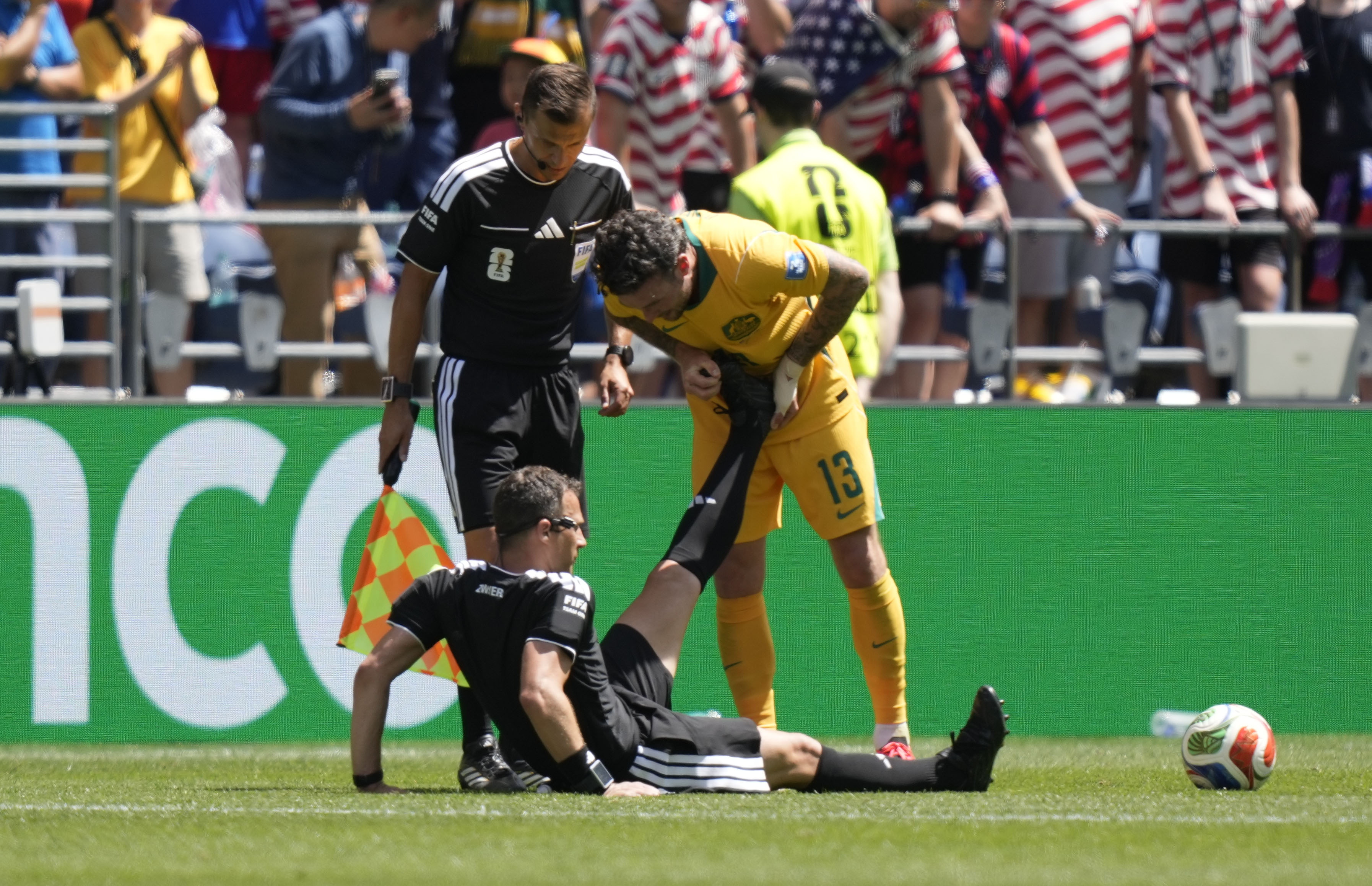 SEATTLE (United States), 19/06/2026.- Aiden O'Neill of Australia (R) helps referee Felix Zwayer (bottom) who sits on the pitch with a cramp during the FIFA World Cup 2026 group stage match USA against Australia, in Seattle, USA, 19 June 2026. EFE/EPA/STEPHAN BRASHEAR