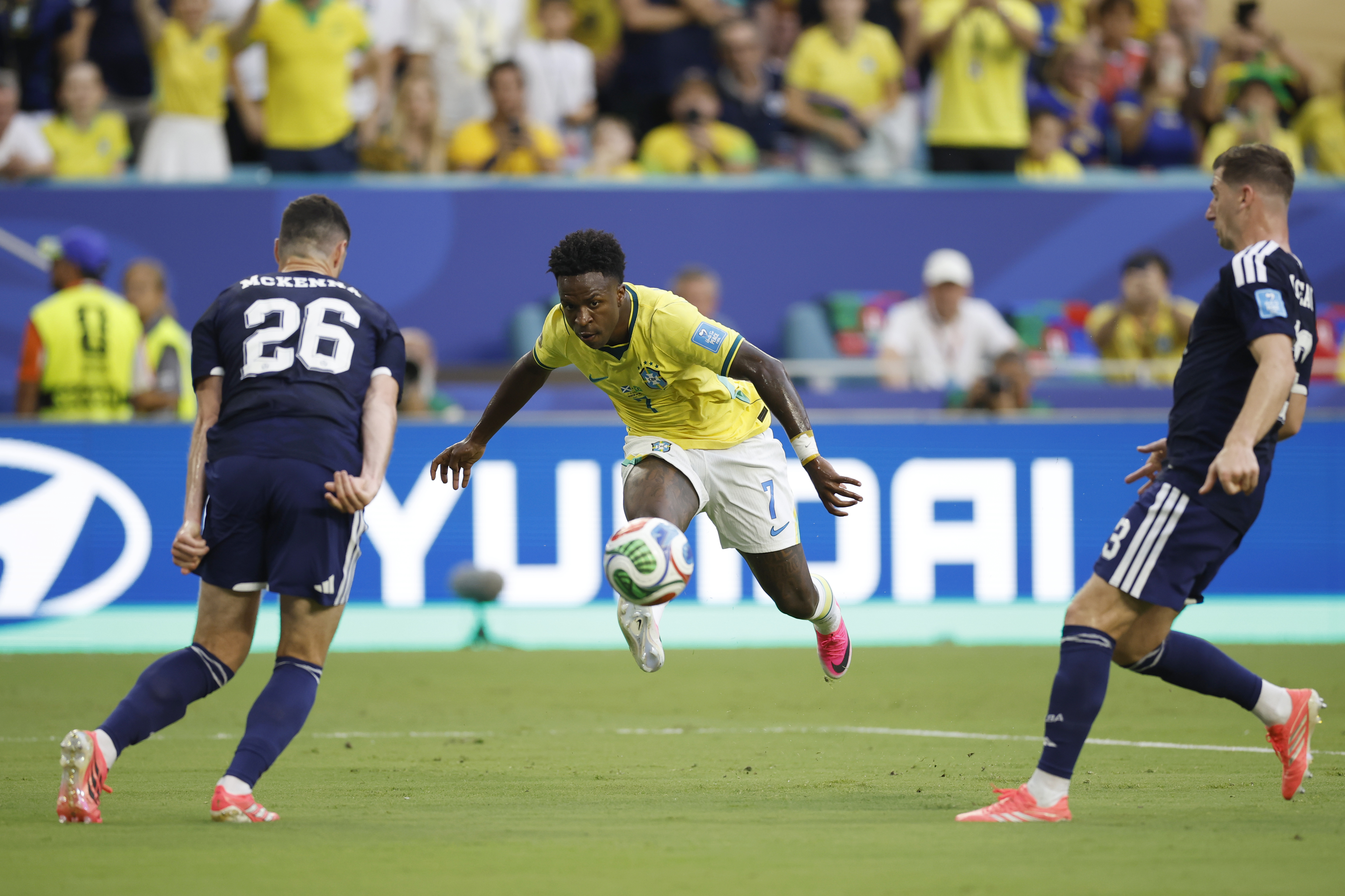 AMDEP7214. MIAMI (ESTADOS UNIDOS), 24/06/2026.- Scott McKenna (i) de Escocia disputa el balón con Vinícius Júnior (c) de Brasil este miércoles, en un partido del grupo C del Mundial de la FIFA 2026 entre Escocia y Brasil, en el estadio Hard Rock en Miami (EE.UU.). EFE/ Alberto Estevez
