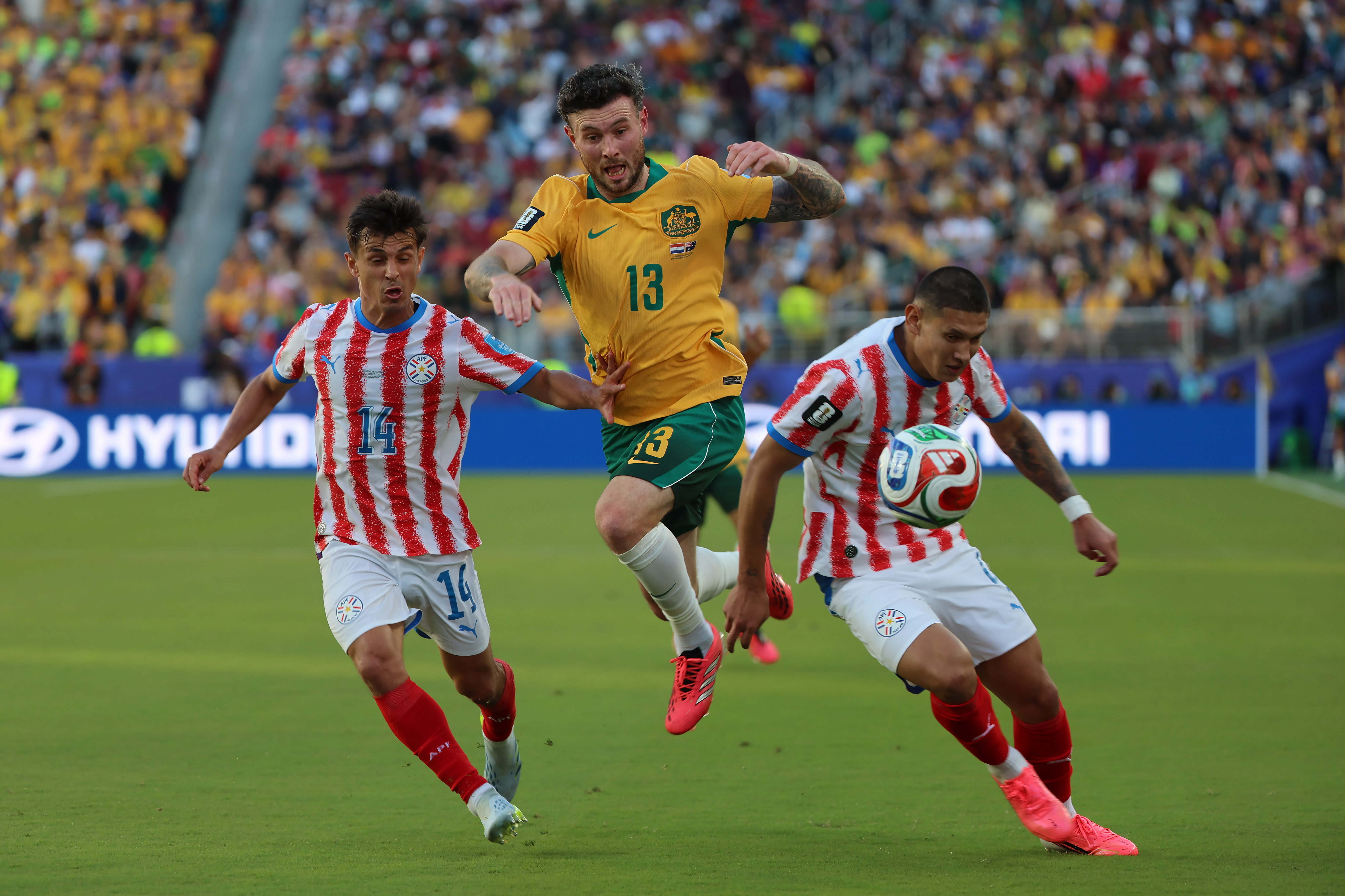 GR5389. SANTA CLARA (ESTADOS UNIDOS), 25/06/2026.- Andrés Cubas (i) y Juan Cáceres (d) de Paraguay disputan el balón con Aiden Oneill (c) de Australia este jueves, en un partido del grupo D del Mundial de la FIFA 2026 entre Paraguay y Australia en el estadio Levi's en Santa Clara, California (Estados Unidos). EFE/ Miguel Gutiérrez