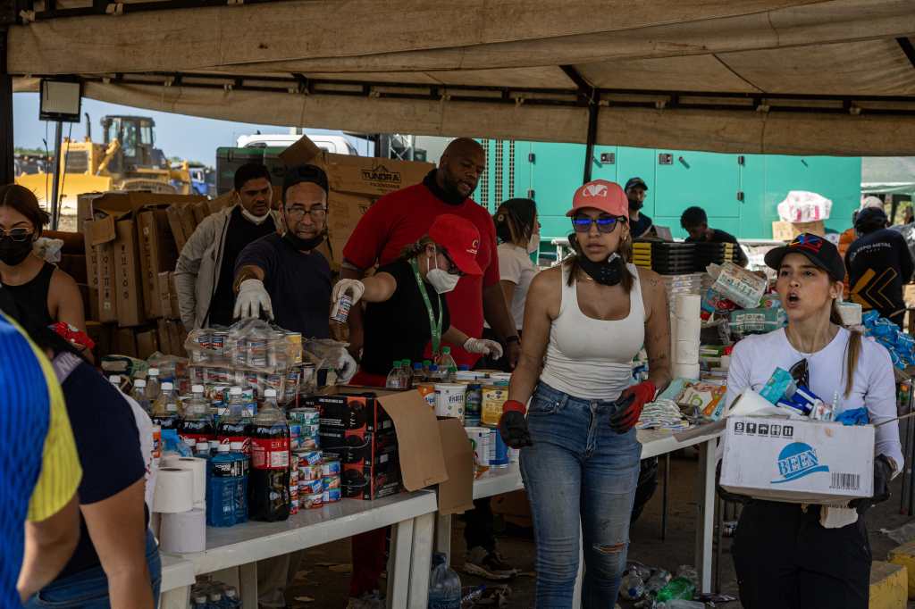 Volunteers and Civil Protection officials organize humanitarian aid this Saturday, in La Guaira, Venezuela. (Photo, Prensa Libre, EFE)