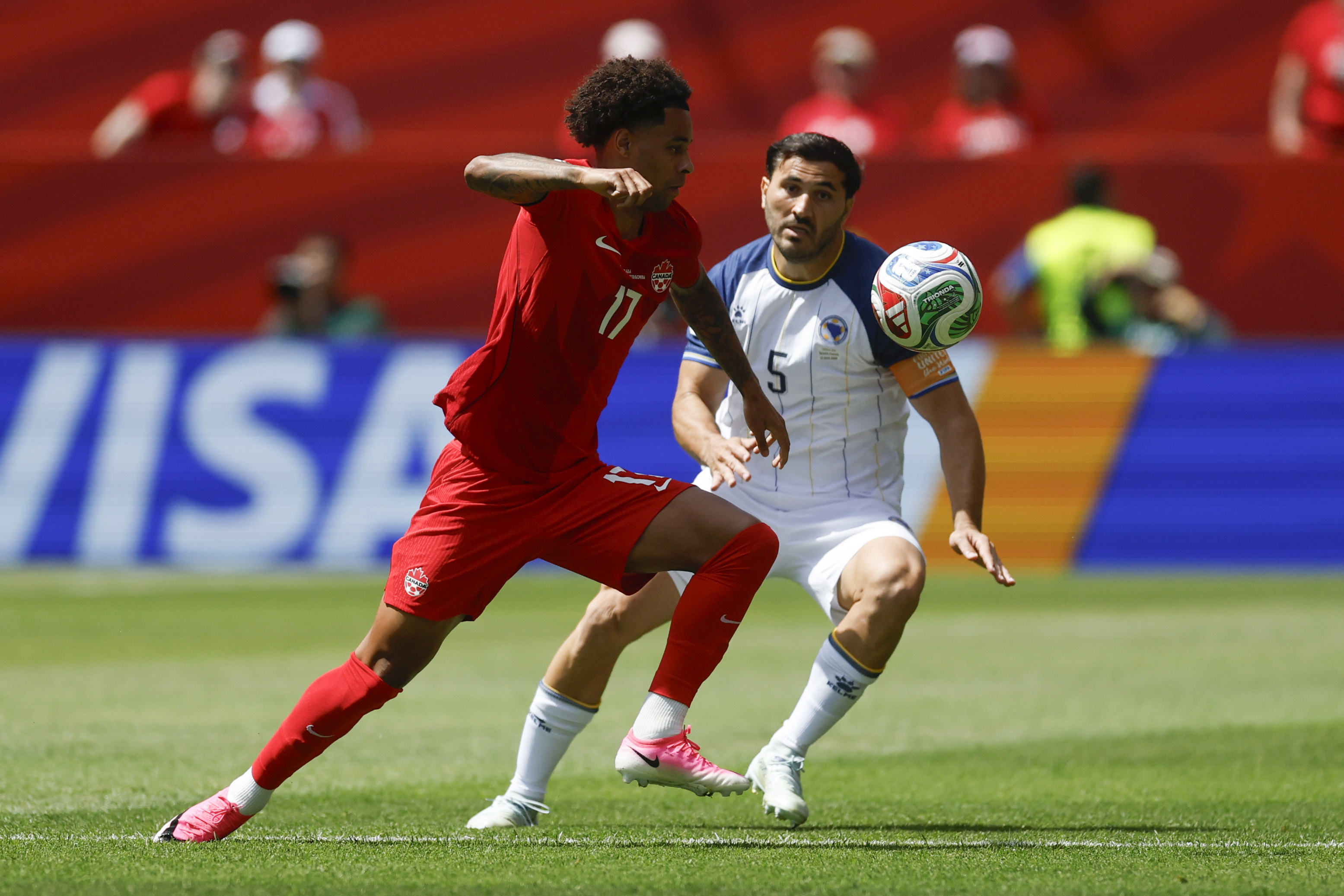 Tajon Buchanan (i) de Canadá disputa el balón con Sead Kolasinac de Bosnia y Herzegovina.(Foto Prensa Libre: EFE).