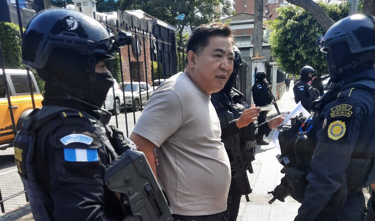 Wenshen Xu, ciudadano chino, permanecía bajo custodia de agentes de la Policía Nacional Civil tras su captura en Guatemala, por solicitud de Estados Unidos. (Foto Prensa Libre: PNC)