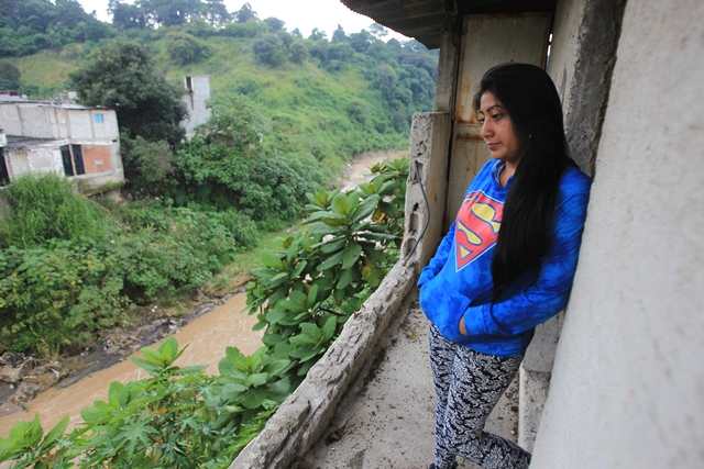  Durante la emergecia del año 2016 una vecina observa desde el segundo nivel de su vivienda el aumento del caudal del río Pinula durante una fuerte lluvia. Tres años antes, en 2013, la corriente destruyó patios y arrasó varias viviendas en el sector. (Foto, Prensa Libre: Juan Diego González)