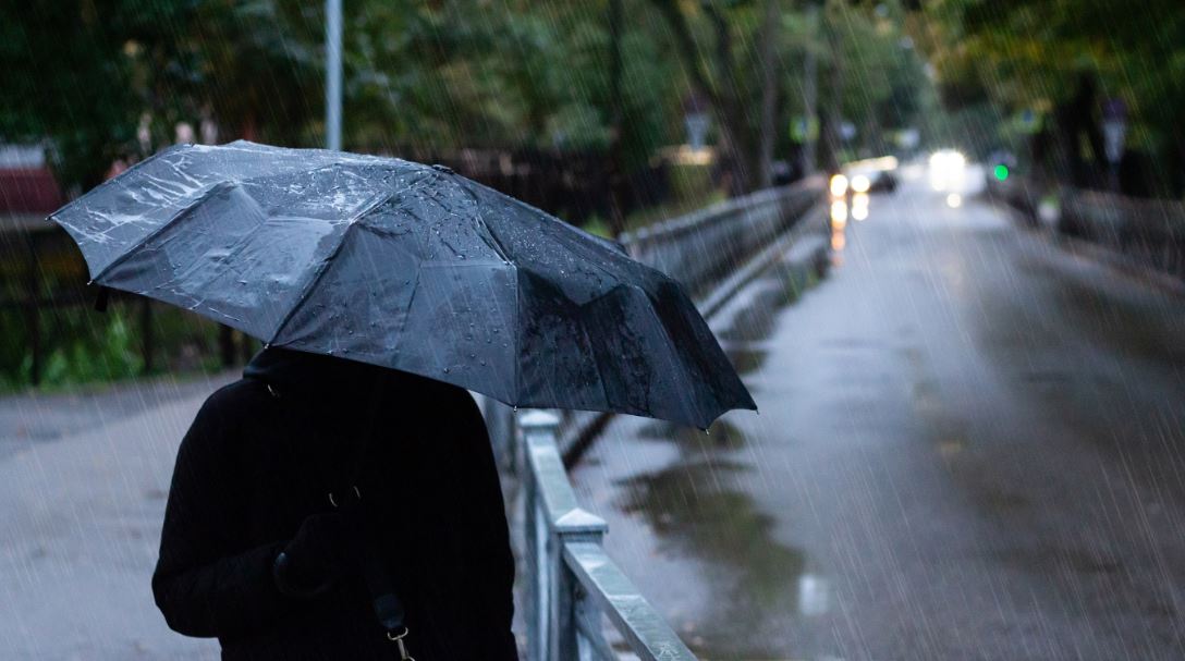 lluvia persona con un paraguas en una carretera Foto SS