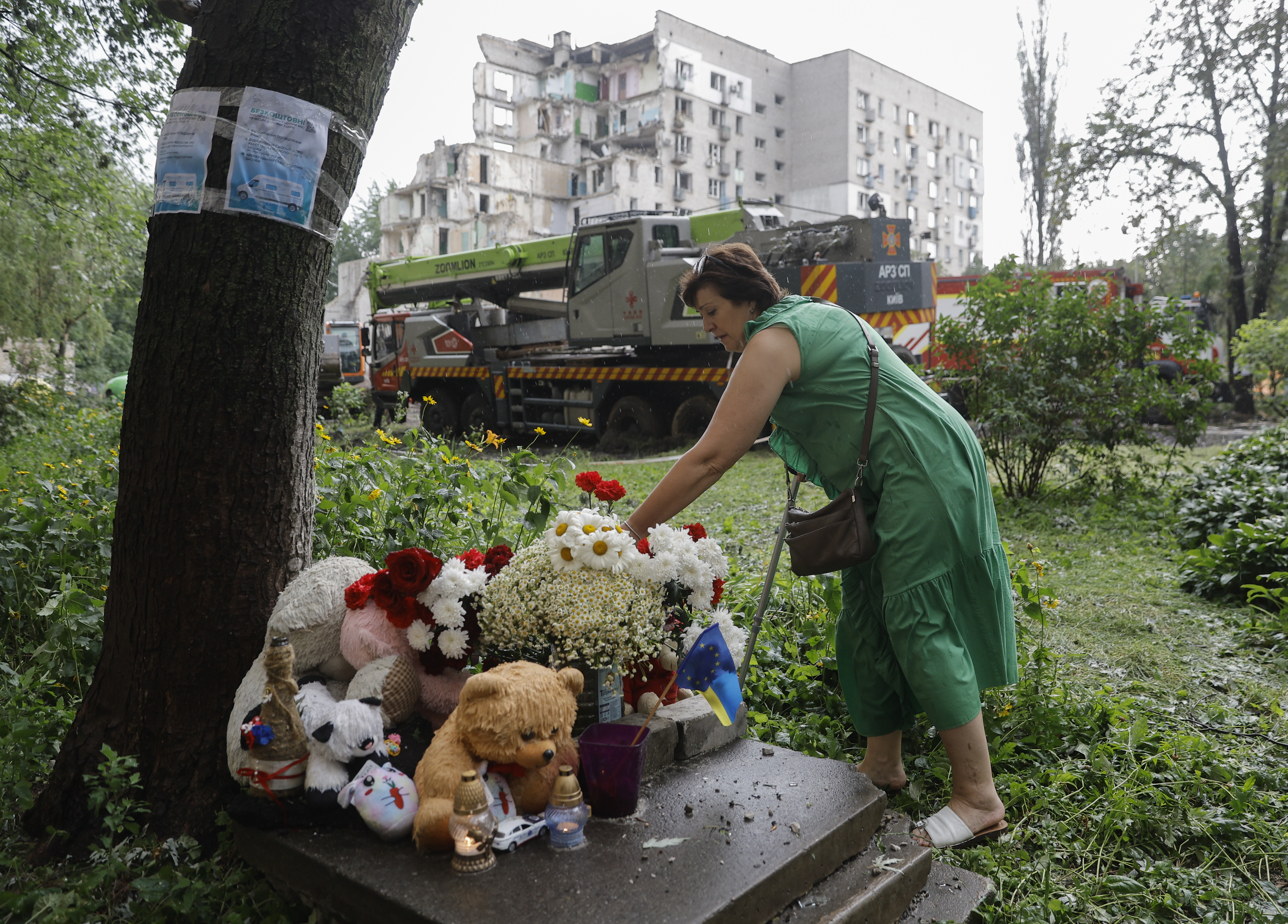KYIV (Ukraine), 03/07/2026.- A Ukrainian woman lays flowers at the site of a Russian strike that hit a nine-storey residential building in Kyiv, Ukraine, 03 July 2026, amid the Russian invasion. At least 30 people were killed and about 100 others injured in a combined Russian attack involving drones and missiles on Kyiv on 02 July 2026, according to the State Emergency Service, as the city declared 03 July a day of mourning for those killed in the attack. (Rusia, Ucrania, Kiev) EFE/EPA/SERGEY DOLZHENKO