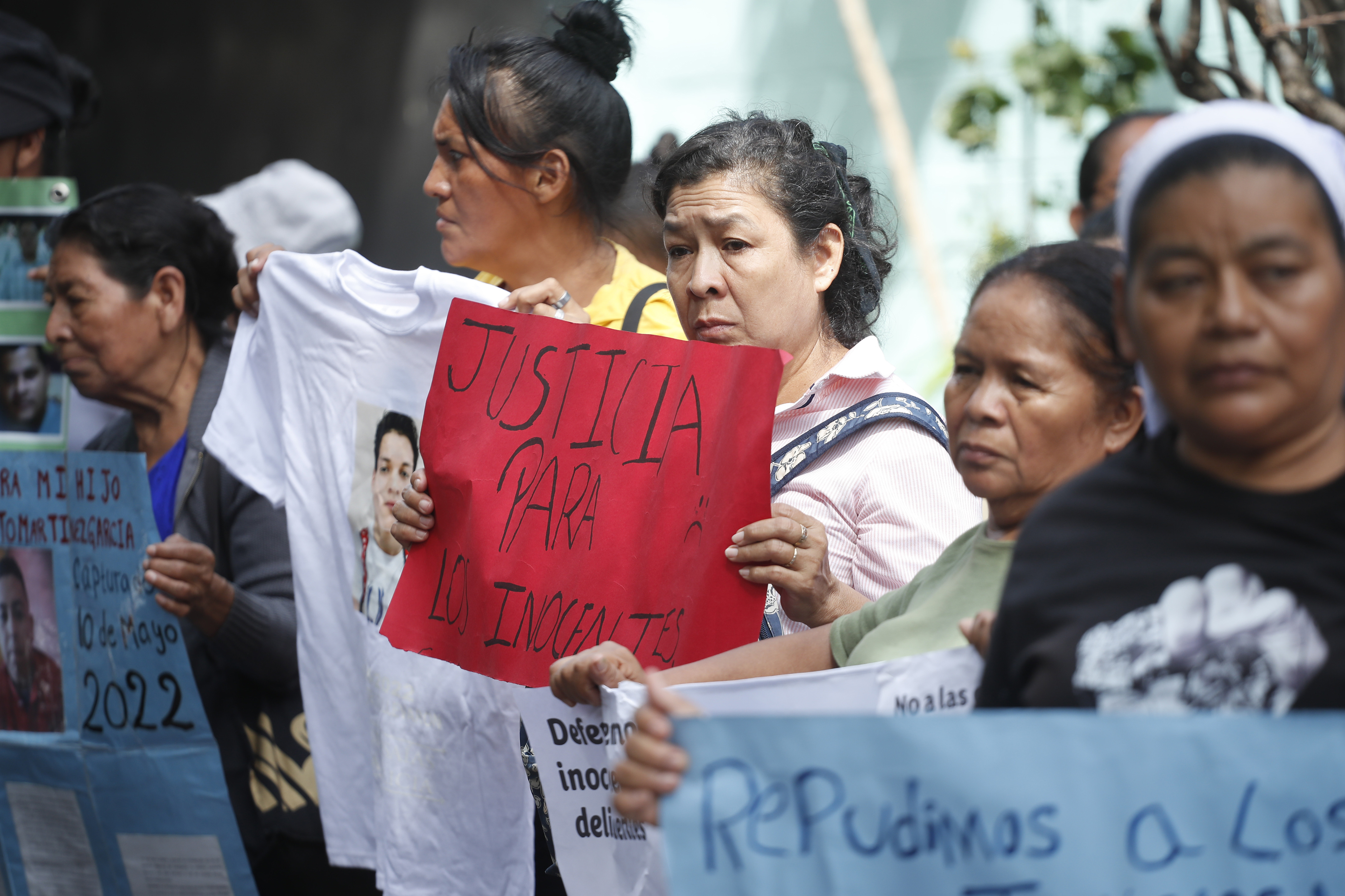 Integrantes de la organización Movimiento de Víctimas del Régimen (Movir) manifiestan contra las audiencias masivas que lleva a cabo la Justicia, en el marco del régimen de excepción, pidiendo que los procesos penales sean "justos" y "transparentes", en Soyapango, San Salvador. (Foto Prensa  Libre: EFE/ Rodrigo Sura).