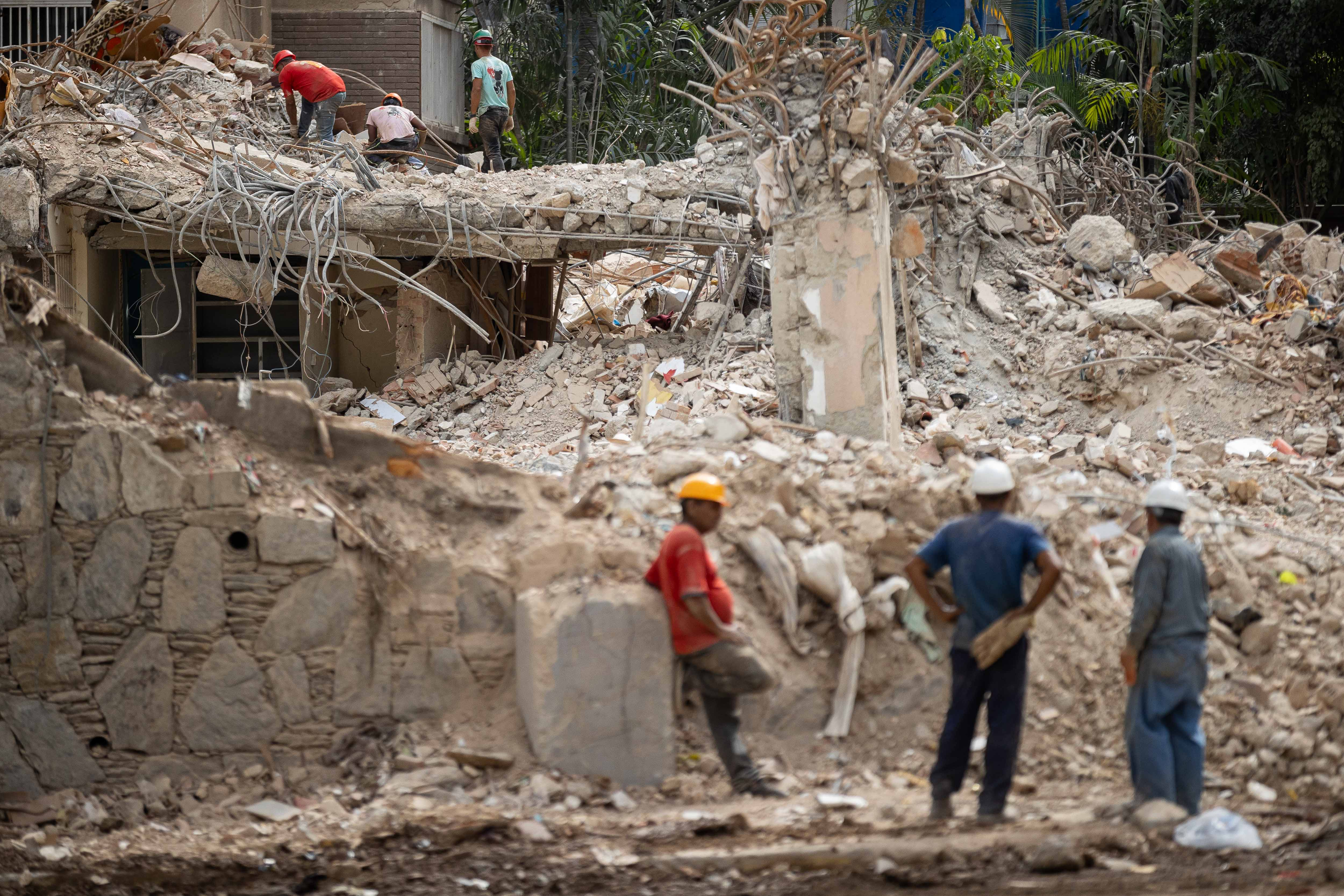FOTODELDÍA AME8734. CARACAS (VENEZUELA), 09/07/2026.- Personas retiran este jueves escombros de un edificio afectado por el doble terremoto en Caracas (Venezuela). La cifra de muertos por los terremotos de hace quince días en Venezuela subió este jueves a 3.899, mientras que la de heridos se mantuvo en 16.740, según el balance oficial. EFE/ Ronald Peña R