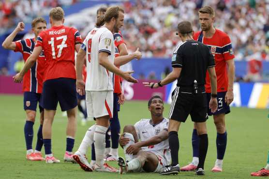 MIAMI (United States), 12/07/2026.- Referee Clement Turpin (2-R) interacts with Players of Norway (in red) and Harry Kane of England (C-L) as Jude Bellingham of England (C) sits on the ground during the FIFA World Cup 2026 quarterfinals match Norway against England, in Miami, Florida, USA, 11 July 2026. (Noruega) EFE/EPA/SHAWN THEW