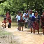 Pobladores de Fray Bartolomé de las Casas, Alta Verapaz, caminan entre el agua y el lodo tras abandonar sus viviendas inundadas por las lluvias. (Foto Prensa Libre: Moisés Xec)