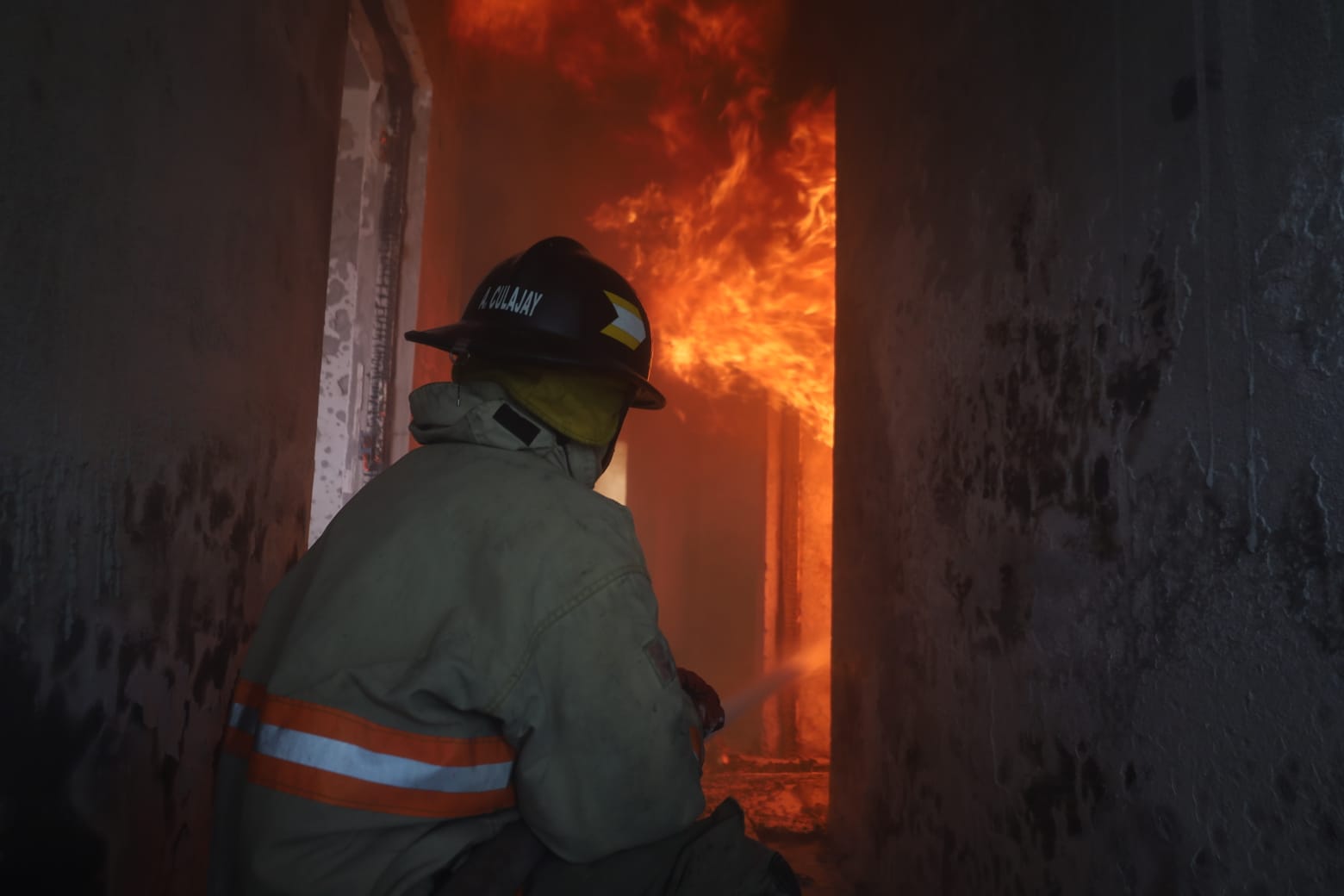 Bomberos Voluntarios rescatan a un hombre de la vivienda en llamas durante la emergencia ocurrida en un residencial de la zona 3 de Mixco. (Foto Prensa Libre: CVB)