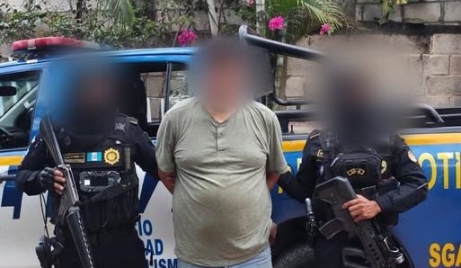 Agentes de la SGAIA de la Policía Nacional Civil trasladan a Erik Orlando Castillo Castillo, capturado en Santa Ana Huista, Huehuetenango, con fines de extradición a EE. UU., donde enfrenta ocho cargos relacionados con delitos sexuales. (Foto Prensa Libre: PNC)
