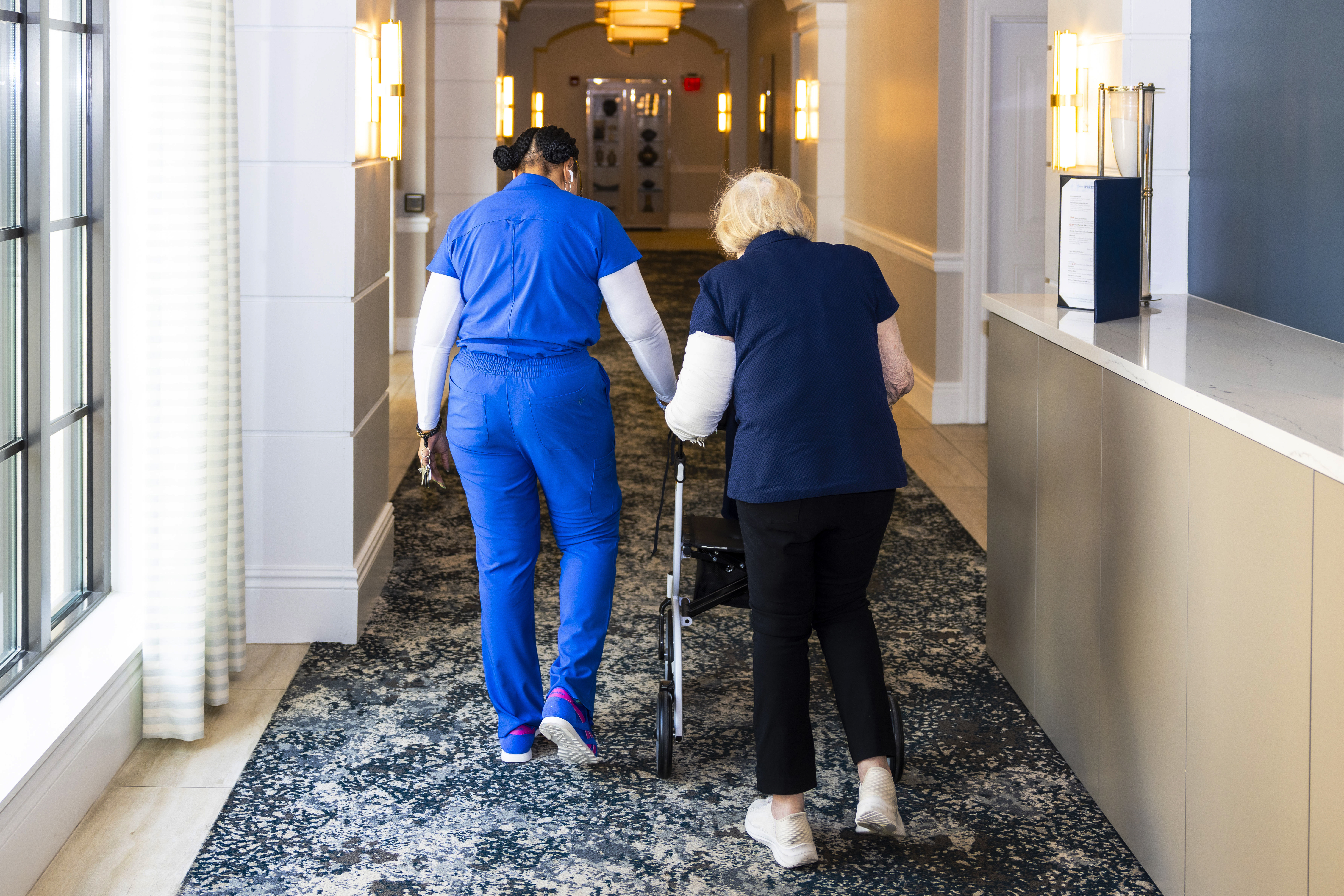 Una integrantes del personal asiste a una residente de los asilos Sinai en Boca Ratón, Florida, en el 2025. (Foto Prensa Libre: Saul Martinez/For The Washington Post)