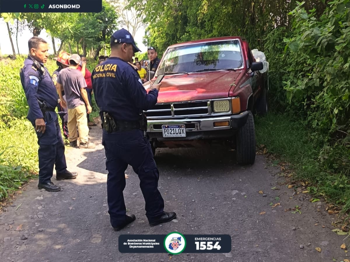 Policías inspeccionan el picop donde fue localizada con vida una niña de 2 años tras el ataque armado en La Democracia, Escuintla.
