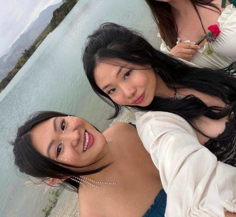 Renee y April, dos jovenes. Una de ellas vestida de azul y la otra de violeta. Estan sobre un campo verde