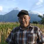 ACOMPAÑA CRÓNICA: GUATEMALA VOLCÁN AME7136. EL RODEO (GUATEMALA), 08/08/2026.- Emilio Barrillas, habitante de las faldas del volcán de Fuego, quien se dedica a la agricultura, regresa a sus cultivos para verificar que las explosiones del volcán no causaran daños a su cosecha de maíz este jueves, en El Rodeo (Guatemala). Barillas, un hombre de 66 años, lleva toda su vida viviendo en la aldea El Rodeo del departamento de Escuintla, 75 kilómetros al sur de la Ciudad de Guatemala y uno de los principales lugares afectados por las explosiones de lava y humo de la erupción de 2018. EFE/ Alex Cruz