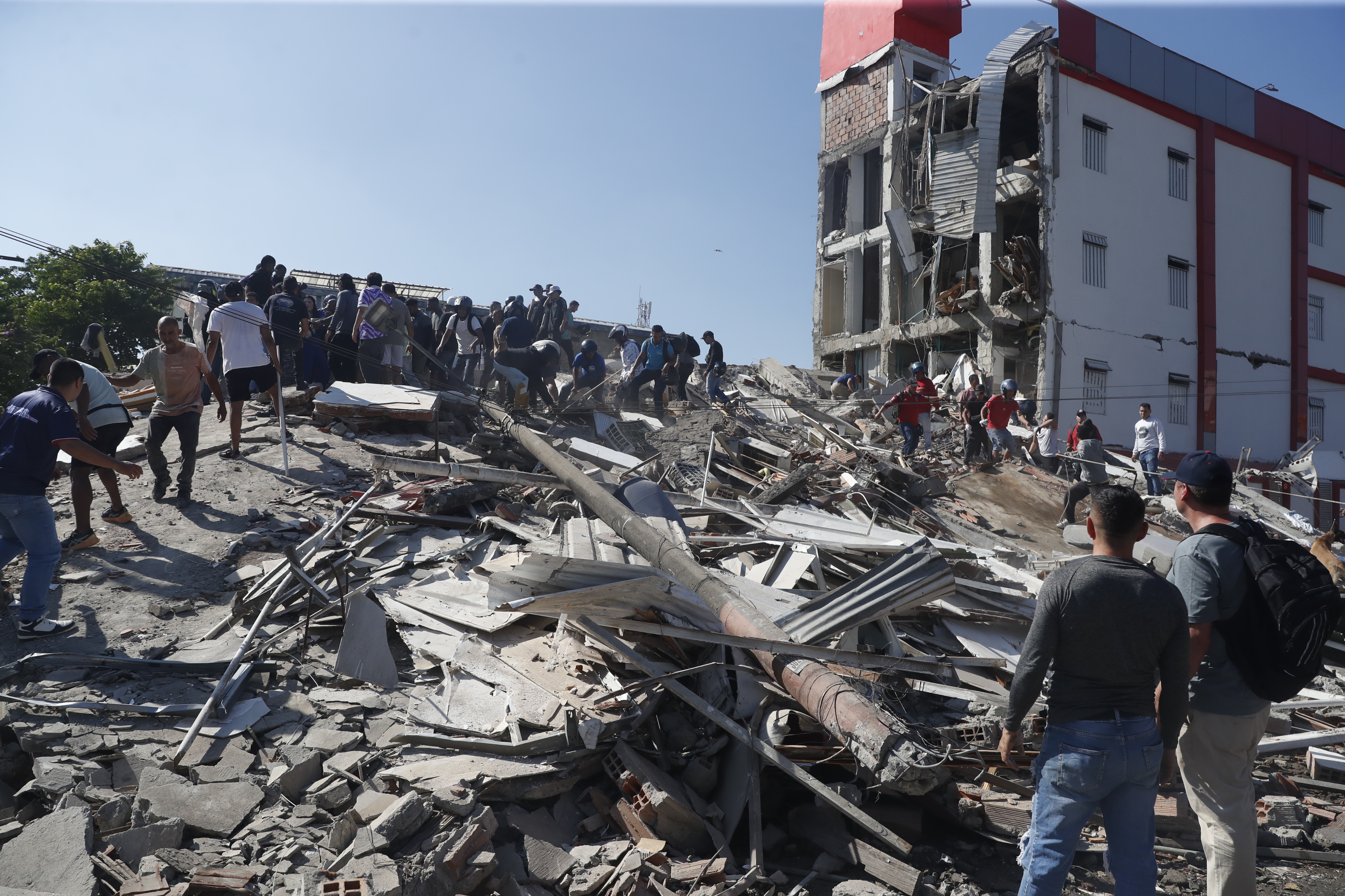 FOTODELDÍA - AME7645. CALI (COLOMBIA), 10/08/2026.- Personas caminan sobre los escombros de un edificio colapsado este lunes, en Cali (Colombia). Al menos 20 edificios sufrieron graves daños por consecuencia del terremoto de magnitud 7,4 que sacudió la mayor parte del país, con epicentro en la zona del Pacífico. EFE/Ernesto Guzmán