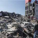 FOTODELDÍA - AME7645. CALI (COLOMBIA), 10/08/2026.- Personas caminan sobre los escombros de un edificio colapsado este lunes, en Cali (Colombia). Al menos 20 edificios sufrieron graves daños por consecuencia del terremoto de magnitud 7,4 que sacudió la mayor parte del país, con epicentro en la zona del Pacífico. EFE/Ernesto Guzmán