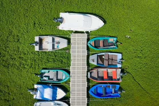 Les Brenets (Switzerland), 22/08/2026.- An aerial view shows stranded boats trapped in a mud-covered area with green grass on the dried out shore of the Lac des Brenets, its Swiss name, or Lac de Chaillexon, the French name, in Les Brenets, Switzerland, 22 August 2026. The lake sits on the Doubs river, a natural border between eastern France and western Switzerland. (sequía, Francia, Suiza) EFE/EPA/PETER KLAUNZER