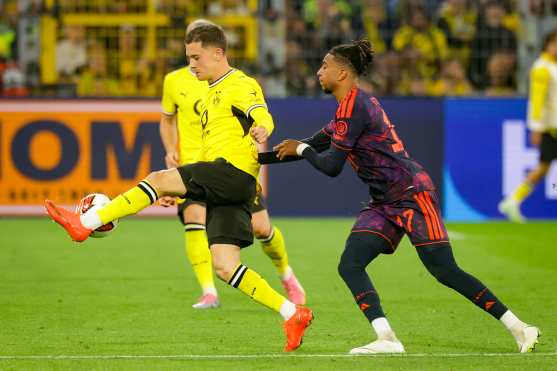 DORTMUND (Germany), 22/08/2026.- Giannis Konstantelias of Dortmund (L) in action against Michael Olise of Munich (R) during the Franz Beckenbauer Supercup match between Borussia Dortmund and Bayern Munich, in Dortmund, Germany, 22 August 2026. (Alemania) EFE/EPA/CHRISTOPHER NEUNDORF CONDITIONS - ATTENTION: The DFL regulations prohibit any use of photographs as image sequences and/or quasi-video.