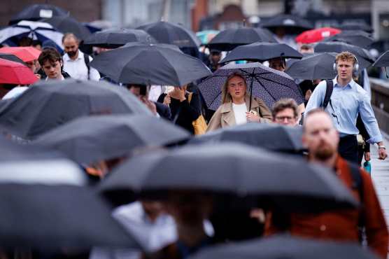 LONDON (United Kingdom), 27/08/2026.- Commuters holding umbrellas cross London Bridge during heavy rainfall in London, Britain, 27 August 2026. The heavy rain forecast comes as 71 percent of England and all of Wales remain officially in drought, even as the Met Office issues thunderstorm warnings across the country with up to a months worth of rain potentially falling on parched ground, bringing warnings of severe flash flooding. (sequía, Reino Unido, Londres) EFE/EPA/TOLGA AKMEN
