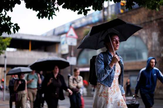 LONDON (United Kingdom), 27/08/2026.- Commuters holding umbrellas cross London Bridge during heavy rainfall in London, Britain, 27 August 2026. The heavy rain forecast comes as 71 percent of England and all of Wales remain officially in drought, even as the Met Office issues thunderstorm warnings across the country with up to a months worth of rain potentially falling on parched ground, bringing warnings of severe flash flooding. (sequía, Reino Unido, Londres) EFE/EPA/TOLGA AKMEN