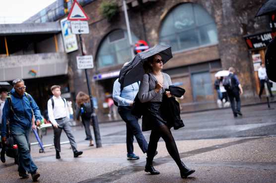 LONDON (United Kingdom), 27/08/2026.- A commuter holds a umbrella during heavy rainfall in London, Britain, 27 August 2026. The heavy rain forecast comes as 71 percent of England and all of Wales remain officially in drought, even as the Met Office issues thunderstorm warnings across the country with up to a months worth of rain potentially falling on parched ground, bringing warnings of severe flash flooding. (sequía, Reino Unido, Londres) EFE/EPA/TOLGA AKMEN