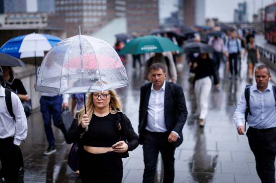 LONDON (United Kingdom), 27/08/2026.- Commuters holding umbrellas cross London Bridge during heavy rainfall in London, Britain, 27 August 2026. The heavy rain forecast comes as 71 percent of England and all of Wales remain officially in drought, even as the Met Office issues thunderstorm warnings across the country with up to a months worth of rain potentially falling on parched ground, bringing warnings of severe flash flooding. (sequía, Reino Unido, Londres) EFE/EPA/TOLGA AKMEN