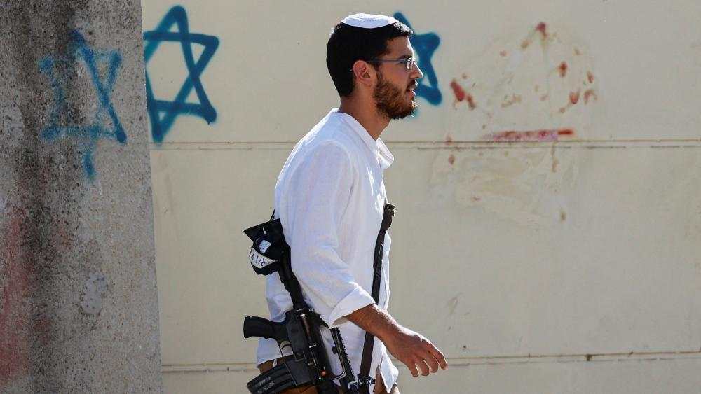 un hombre vestido de blanco que carga un rifle