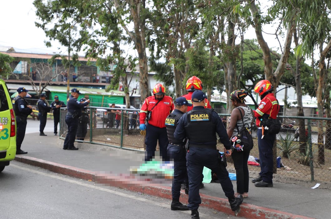 Agentes de la Policía Nacional Civil y socorristas de los Bomberos Municipales resguardan la escena donde dos personas murieron en un ataque armado, en el puente El Trébol. (Foto Prensa Libre: CBM) 