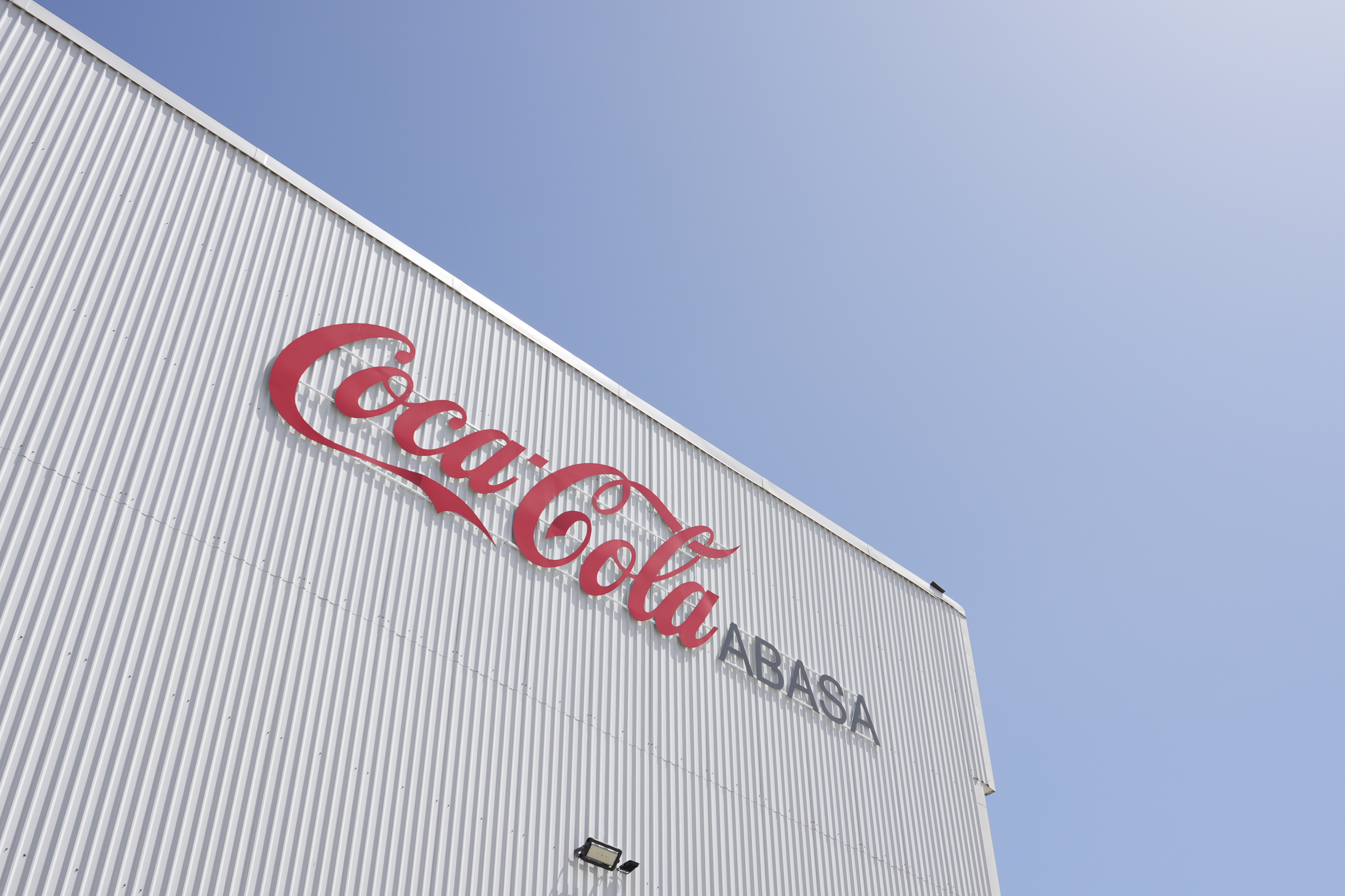 Logo de Coca-Cola en la fachada de la planta de Coca-Cola ABASA en Río Hondo, Zacapa.