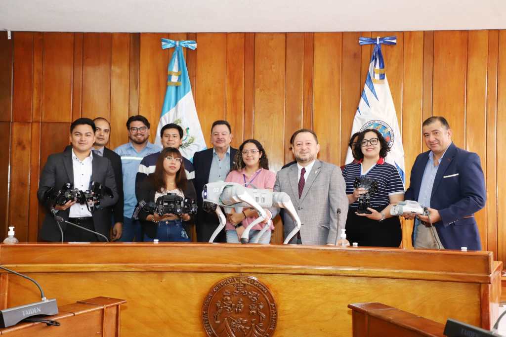Estudiantes de la USAC posan junto al rector durante la entrega del perro robot en el Campus Central