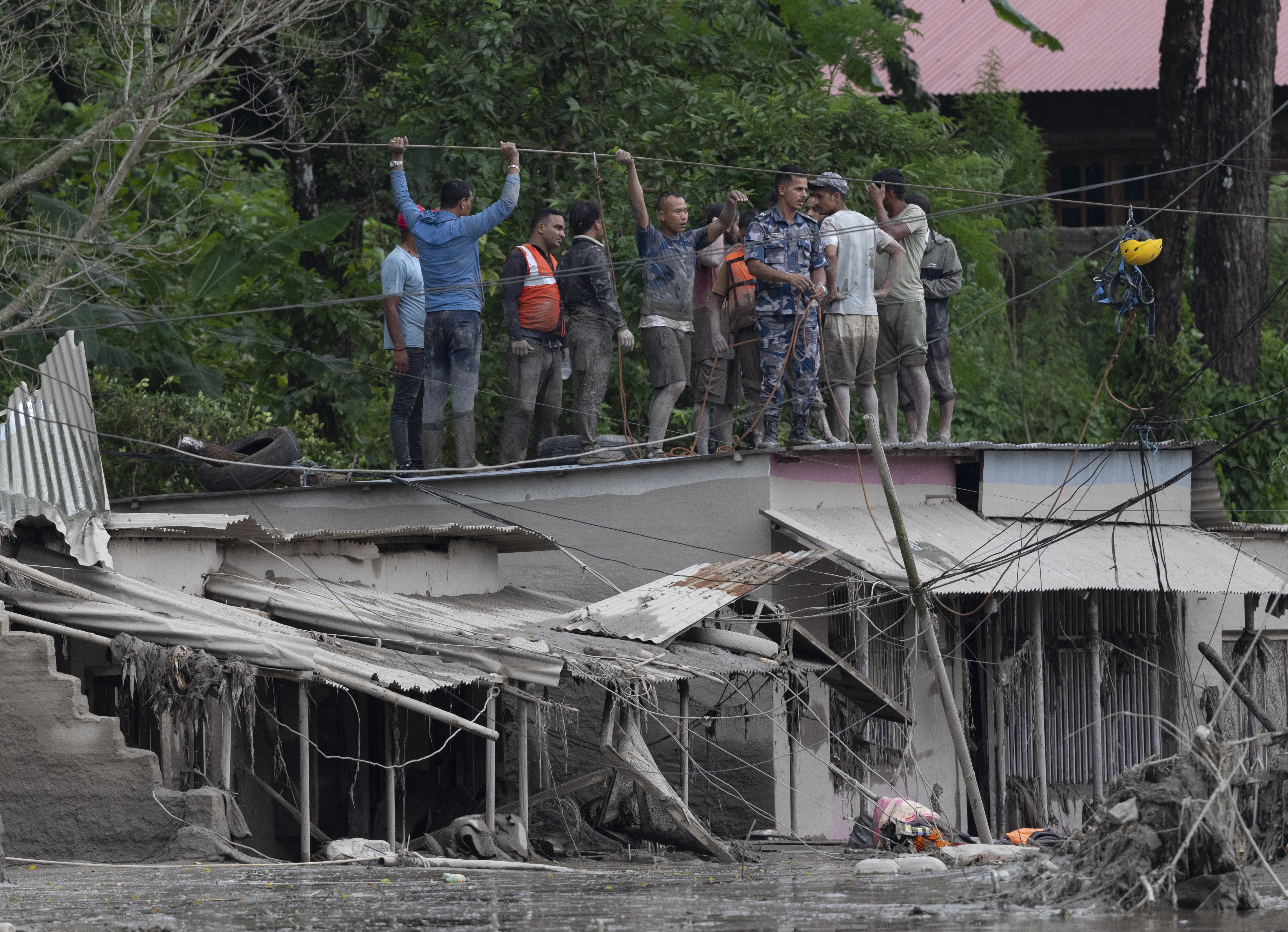 Trishuli Bazar (Nepal), 26/08/2026.- Rescuers gather on a rooftop as floodwaters sweep through Trishuli Bazar following a flash flood, in Nuwakot district, Nepal, 26 August 2026. Several people were killed and multiple others were reported missing after a massive flash flood swept through Rasuwa and Nuwakot districts causing widespread destruction to settlements and infrastructure, according to local authorities. (Inundaciones) EFE/EPA/NARENDRA SHRESTHA
