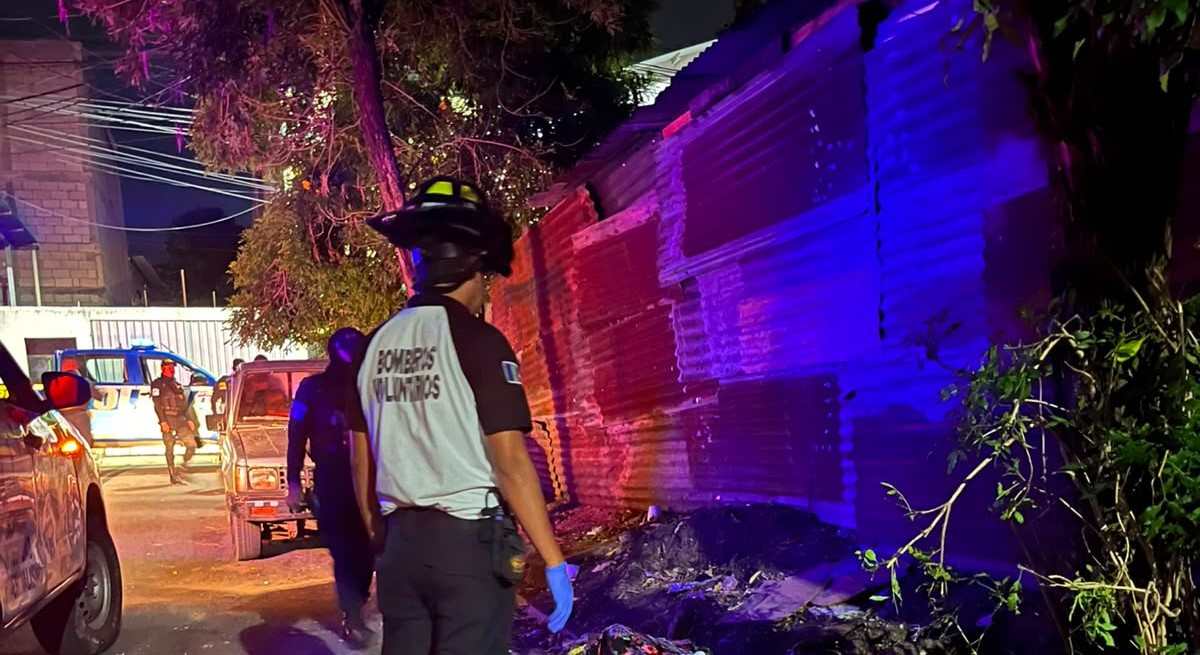 Agentes de la Policía Nacional Civil acordonan el área donde fueron localizados dos cuerpos envueltos en sábanas, en la colonia San Miguelito, zona 1 de Villa Nueva. (Foto Prensa Libre: CVB)