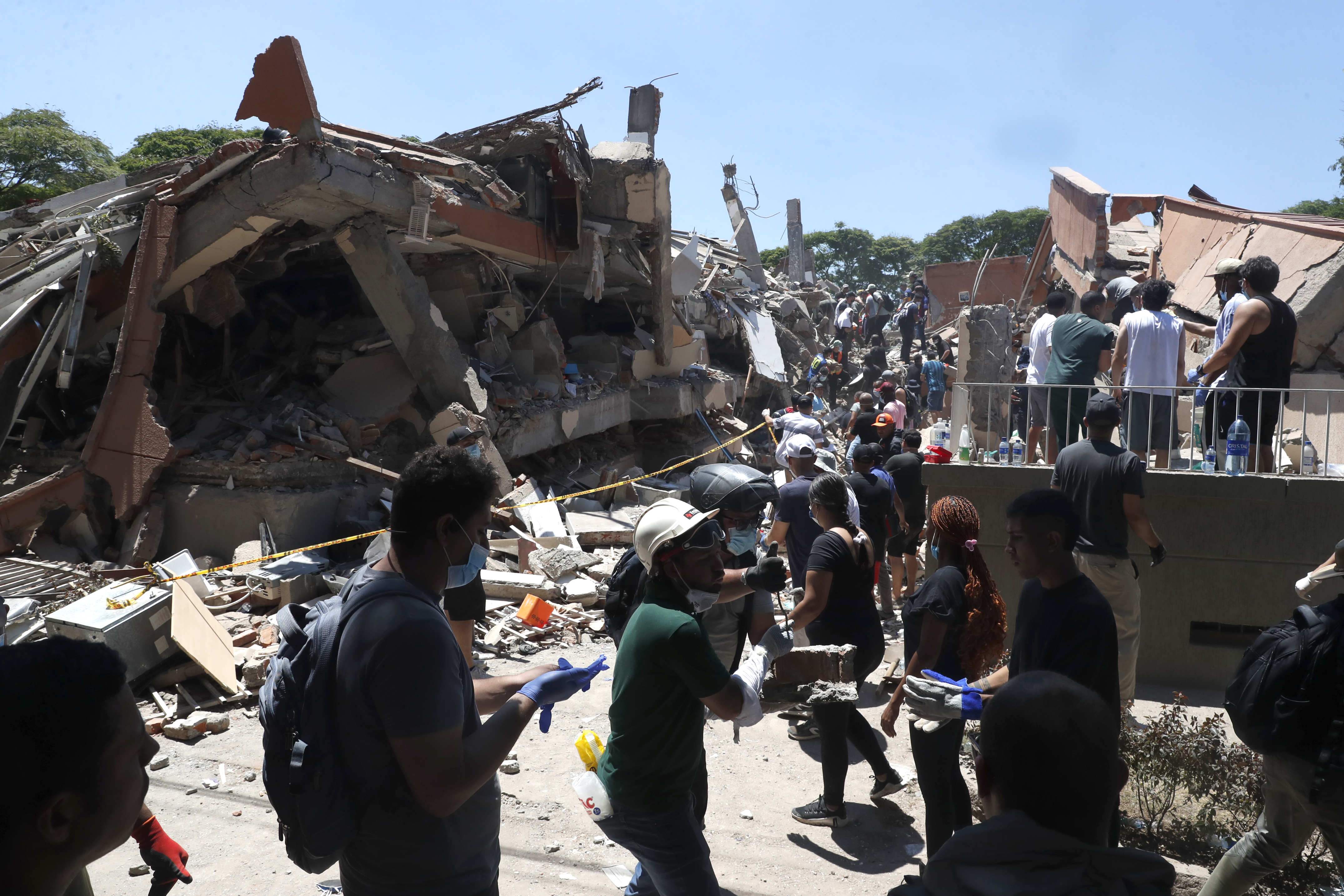 AME7690. CALI (COLOMBIA), 10/08/2026.- Integrantes del cuerpo de Bomberos de Cali y civiles buscan entre los escombros de edificaciones colapsadas por el terremoto de magnitud 7,4 que sacudió esta mañana el país, este lunes en Cali (Colombia). El Gobierno colombiano declaró la situación de "desastre nacional" por el terremoto que deja al menos 71 personas fallecidas en el país, 29 de ellas en ciudades capitales. EFE/ Ernesto Guzmán Jr