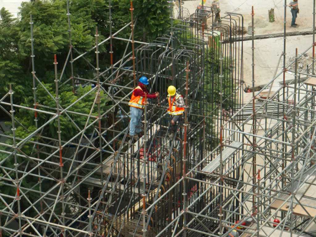 Trabajadores construyen la estructura del AeroMetro en la calle Montúfar, zona 9 de la Ciudad de Guatemala, utilizando andamios y refuerzo de acero.