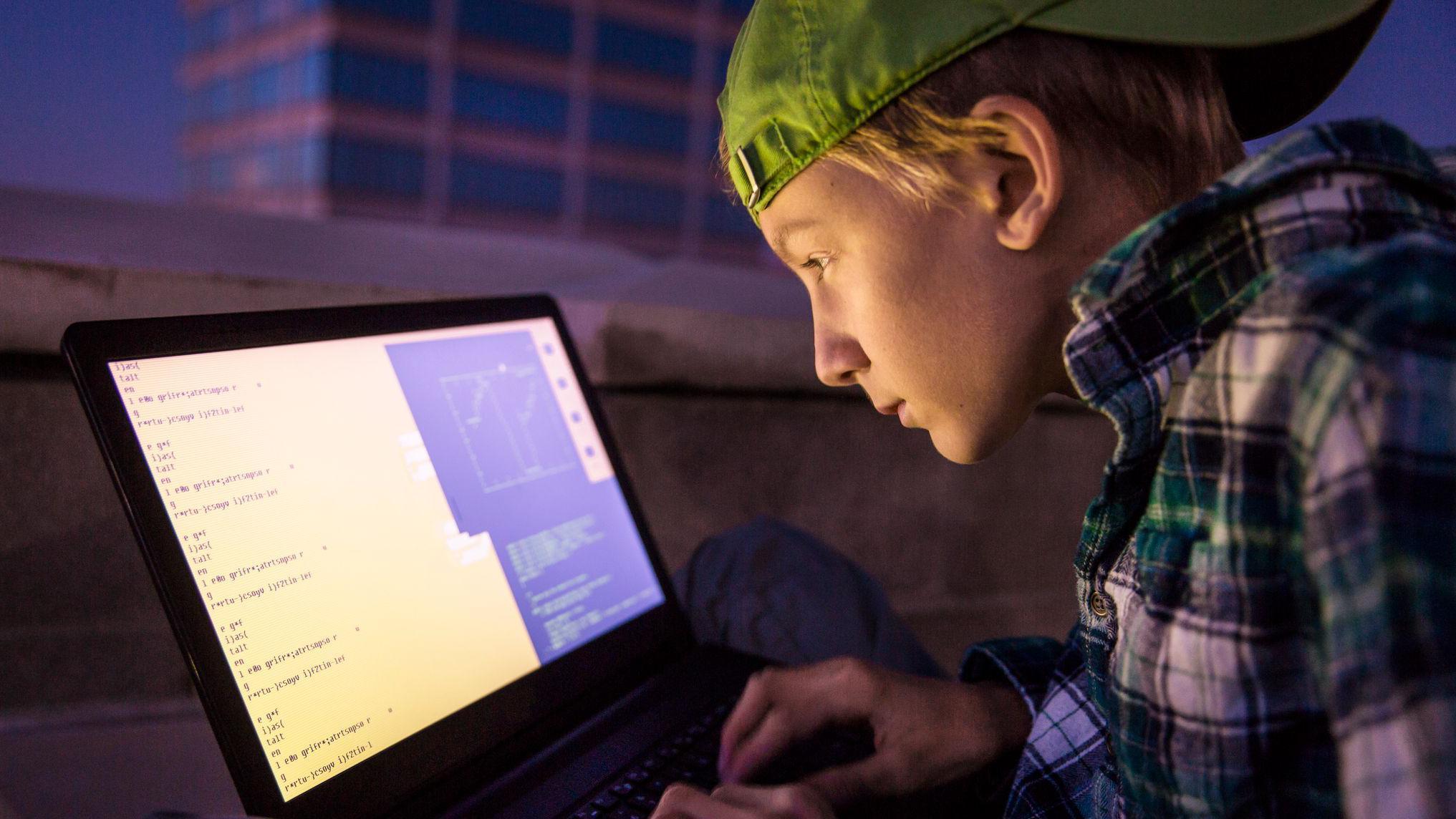un joven frente a una computadora
