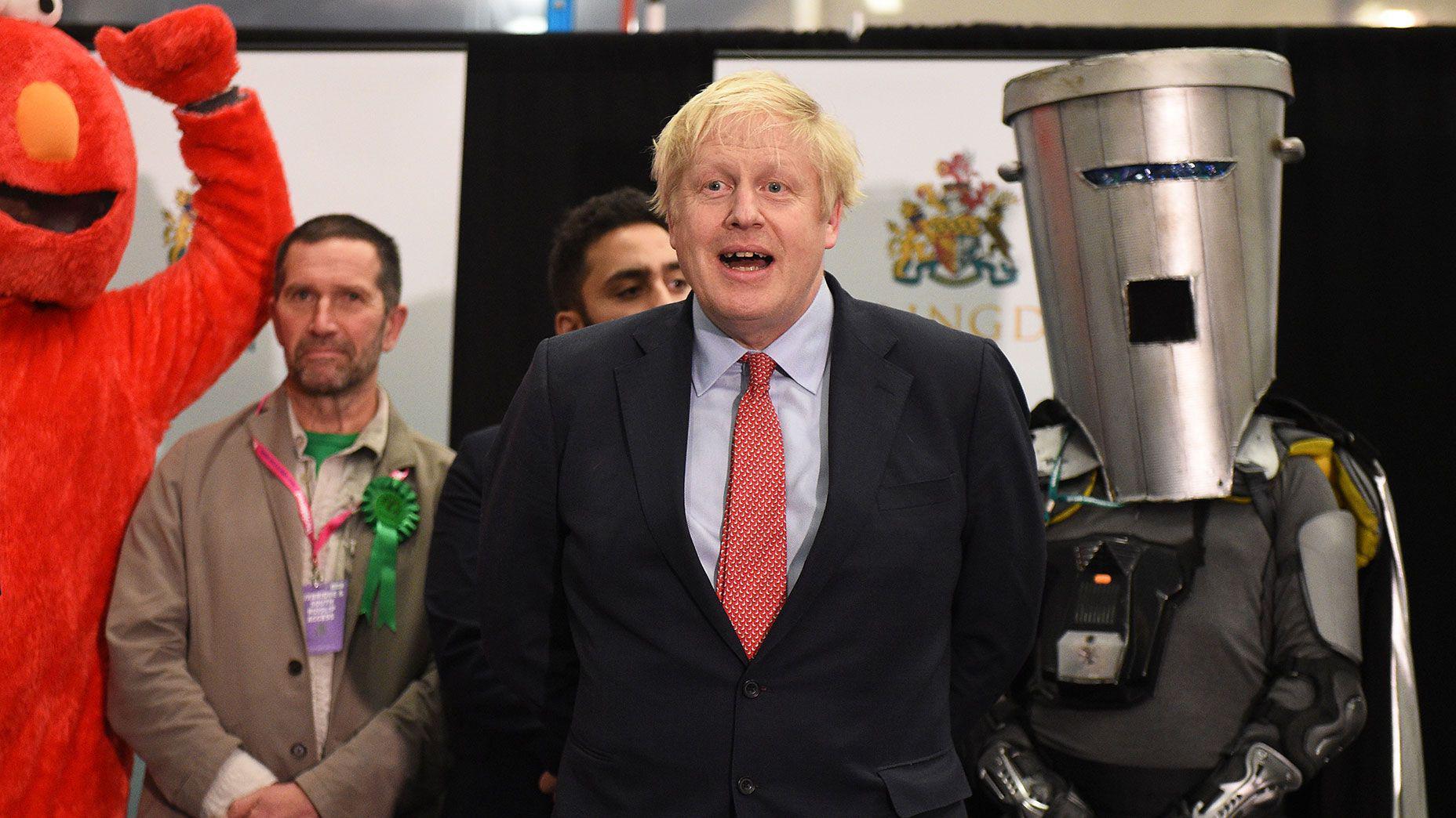 A split screen showing a man with a bin on his head posing triumphantly outside the Houses of parliament and a close up of a colourful poster with the word 'Vote' and a picture of Count Binface held to the camera ( left)