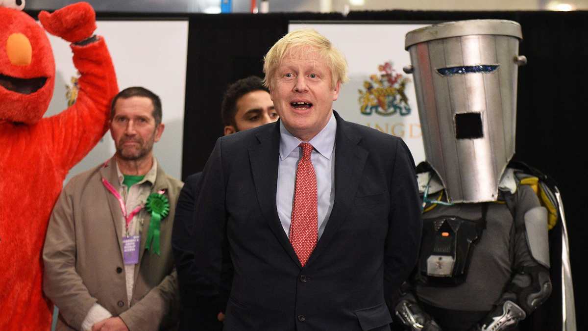 A split screen showing a man with a bin on his head posing triumphantly outside the Houses of parliament and a close up of a colourful poster with the word 'Vote' and a picture of Count Binface held to the camera ( left)
