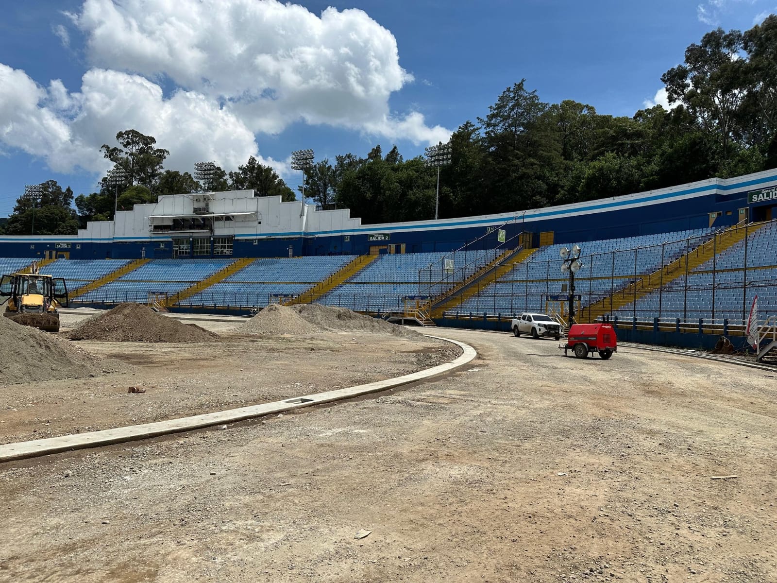 Trabajos de remodelación en la cancha del Estadio Nacional Doroteo Guamuch Flores sin gramilla y con montículos de piedrín en el área central.