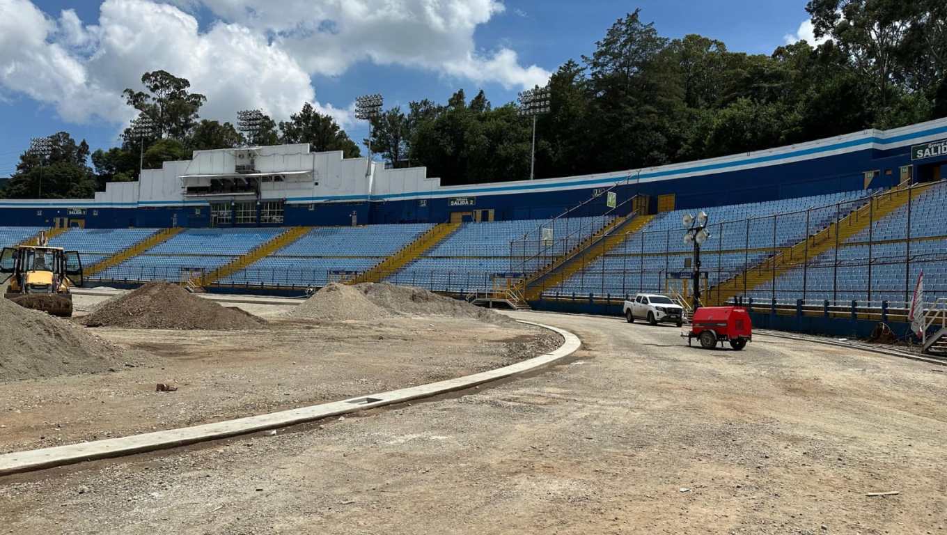 Trabajos de remodelación en la cancha del Estadio Nacional Doroteo Guamuch Flores sin gramilla y con montículos de piedrín en el área central.