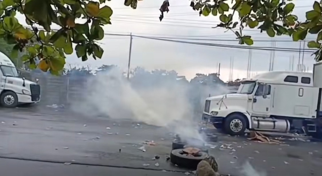 Agentes antimotines de la PNC lanzan gases lacrimógenos durante el desalojo de manifestantes en Cuyotenango, Suchitepéquez. (Foto Prensa Libre: Captura de pantalla tomada del Facebook Noticias Pueblo Nuevo Suchitepéquez)