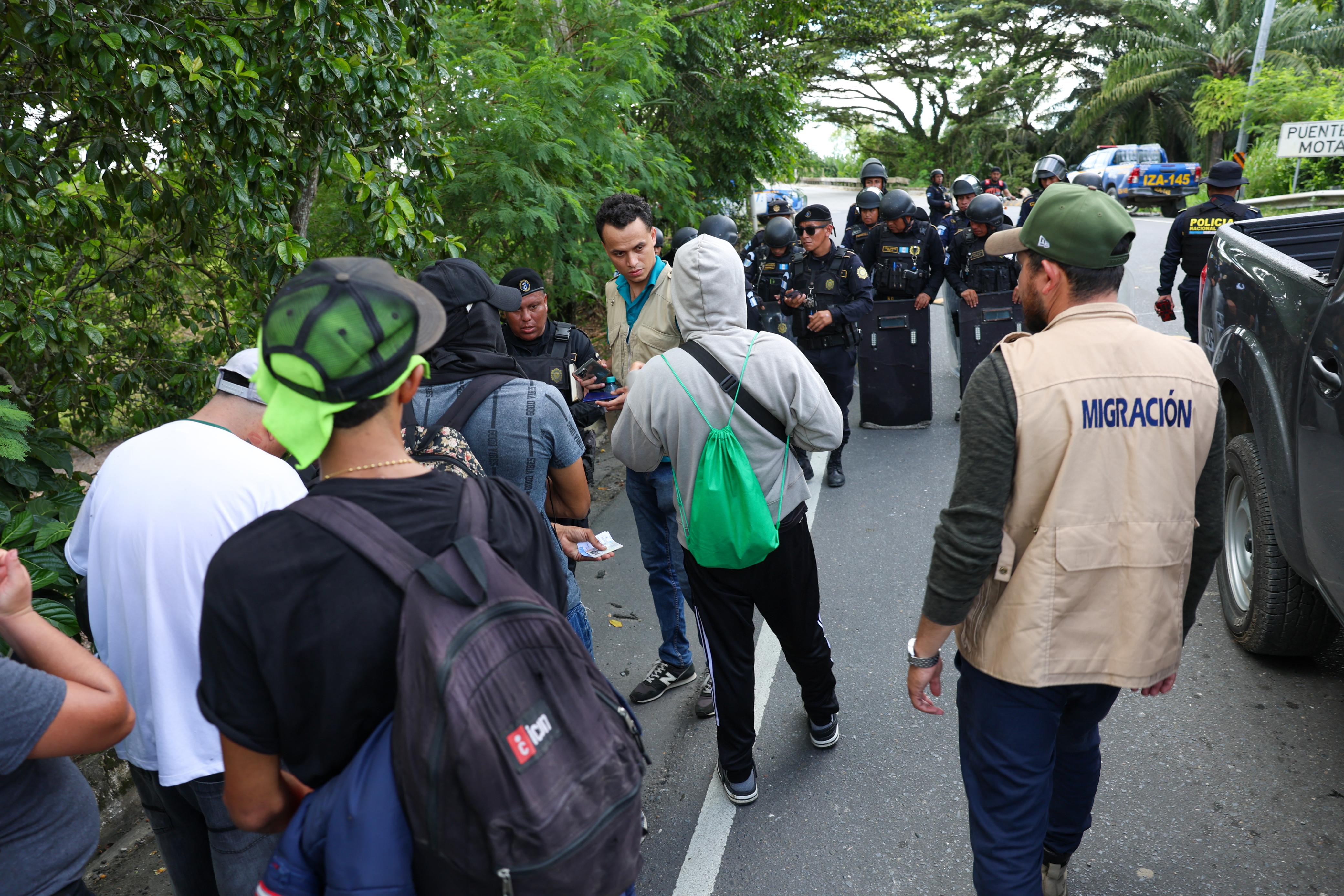 Personal del Instituto Guatemalteco de Migración y agentes de la Policía Nacional Civil verifican a un grupo de migrantes durante uno de los controles implementados por las autoridades. (Foto Prensa Libre: Cortesía de IGM)